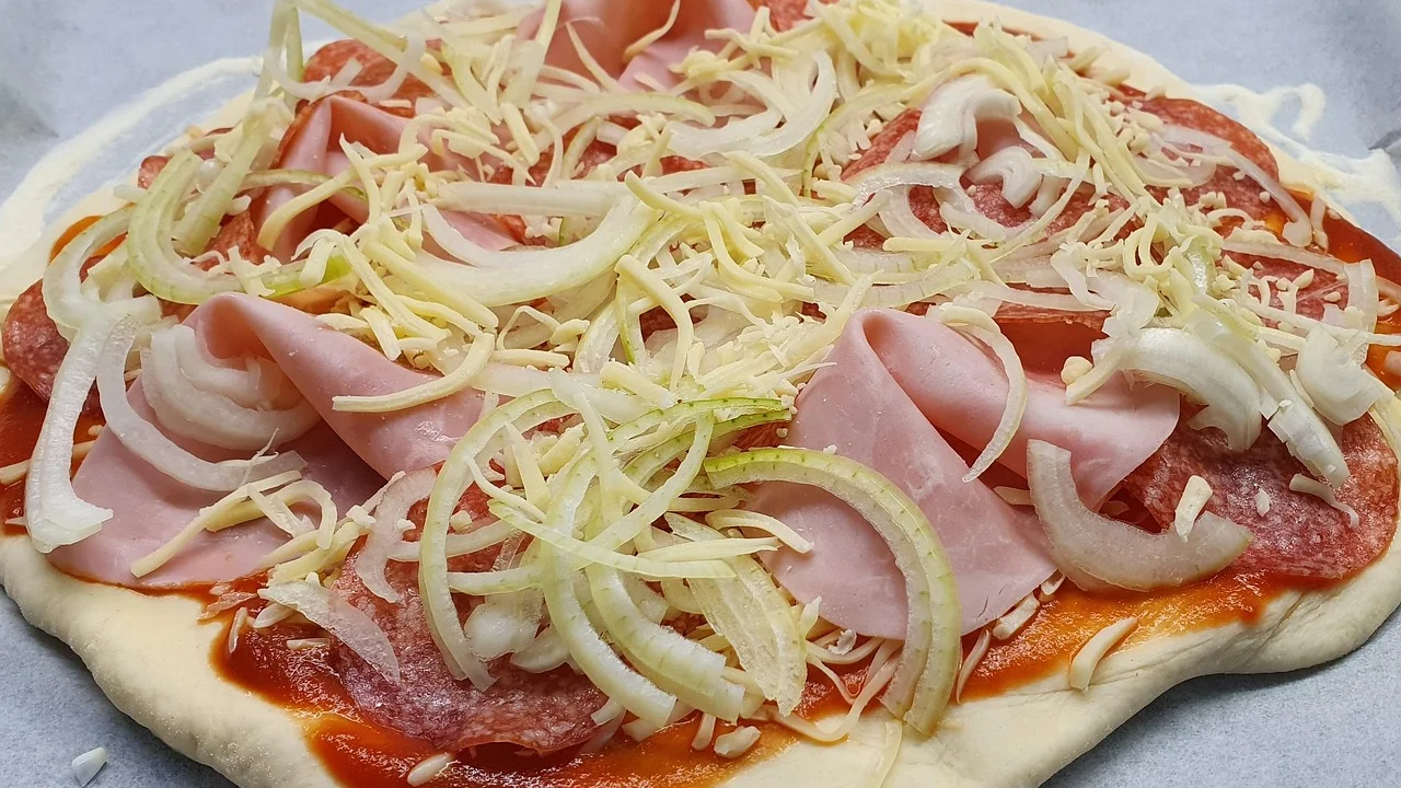 Ingredientes secos e molho equilibrado sobre massa pronta para assar.