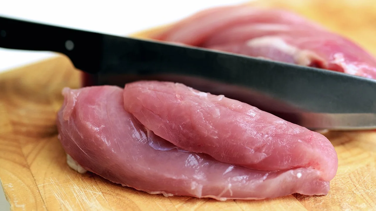 Frango inteiro sobre tábua limpa antes do corte