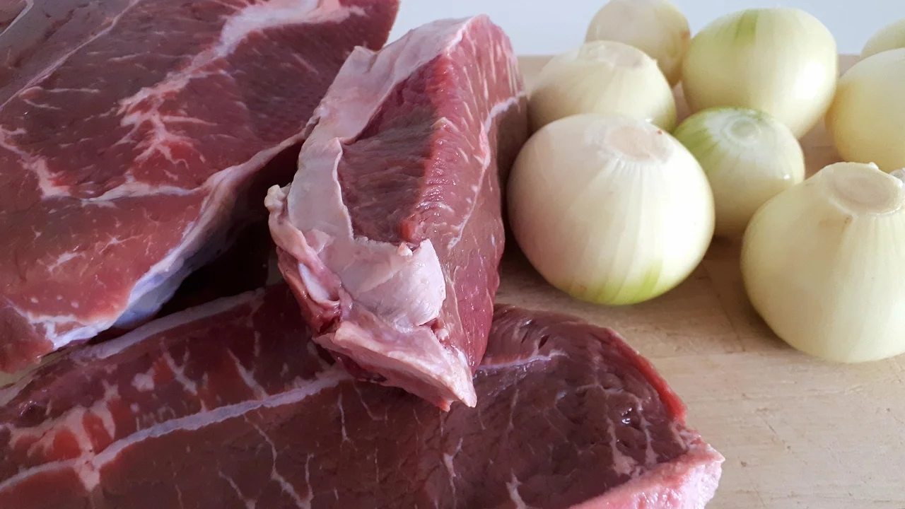 Cubos de carne bovina dourando no fundo da panela de pressão.