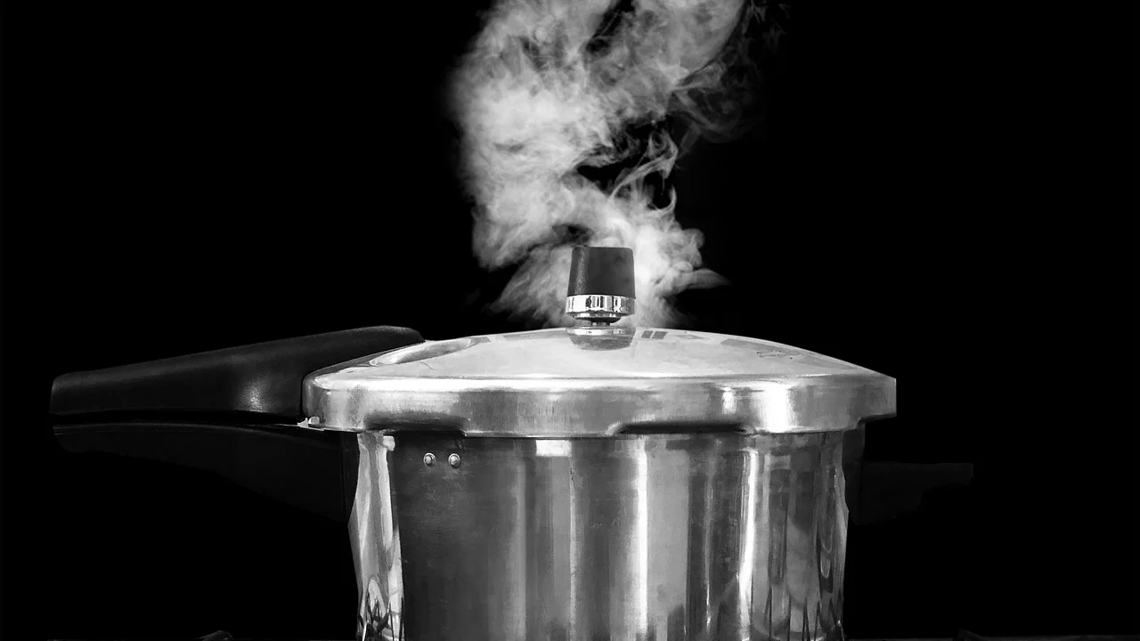 Frango temperado sendo preparado em panela de pressão.
