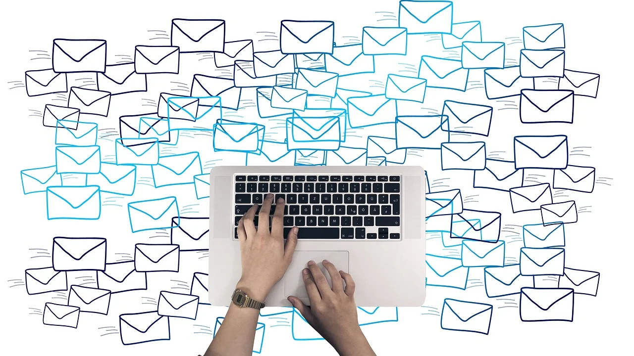 Profissional conferindo e-mails em uma mesa de trabalho