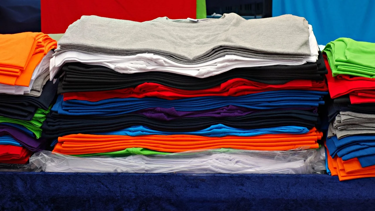 Camisetas enroladas organizadas em uma mala de viagem