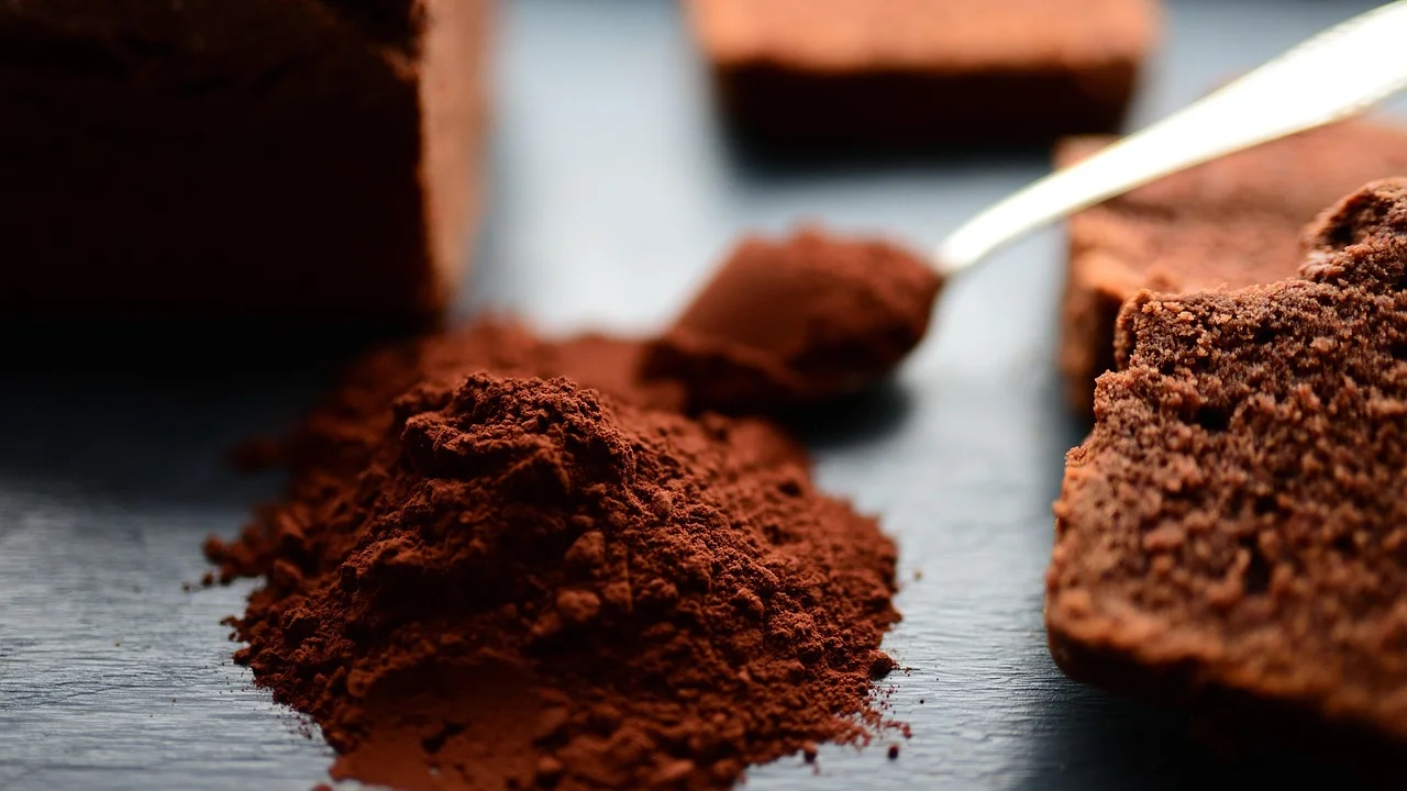 Leite quente recebendo o pó de chocolate caseiro