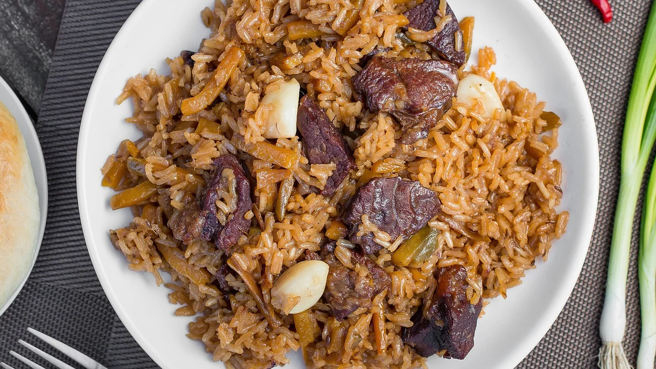 Arroz carreteiro servido em panela de ferro com cheiro-verde fresco.