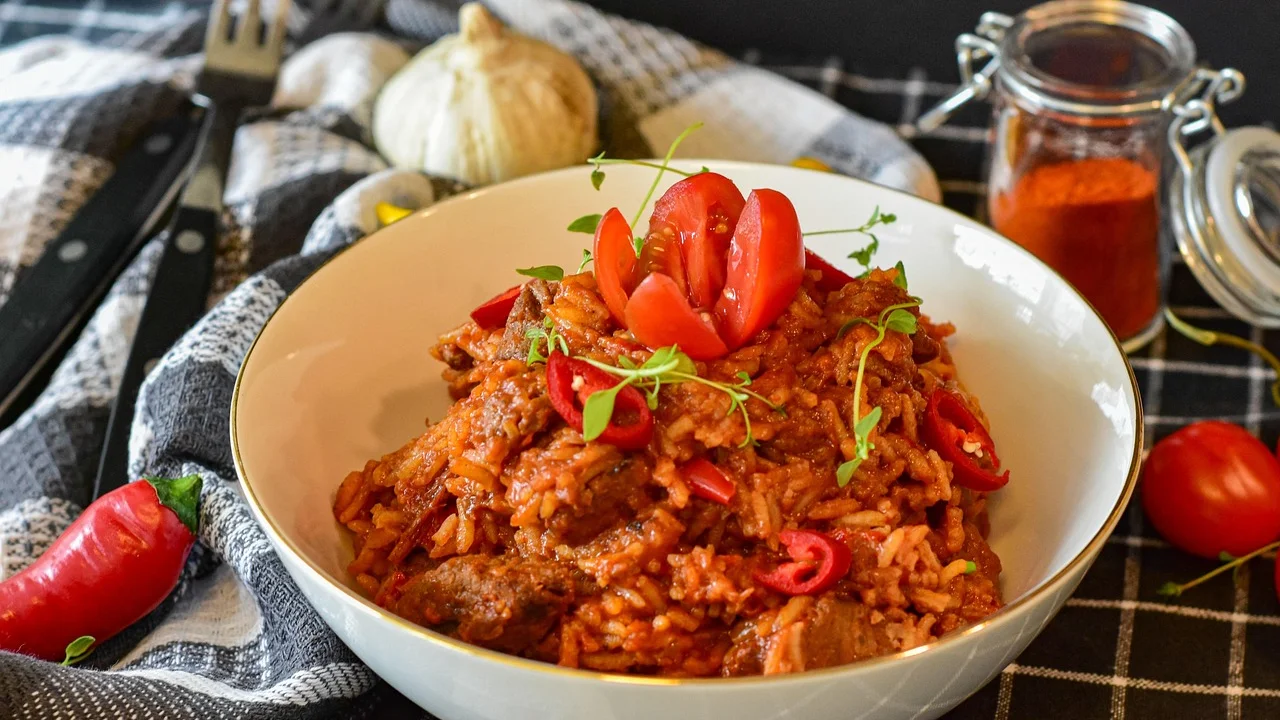 Carne-seca desfiada dourando com cebola e alho na panela.