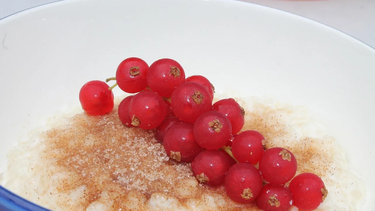 Arroz doce cremoso servido em tigela com canela em pó.