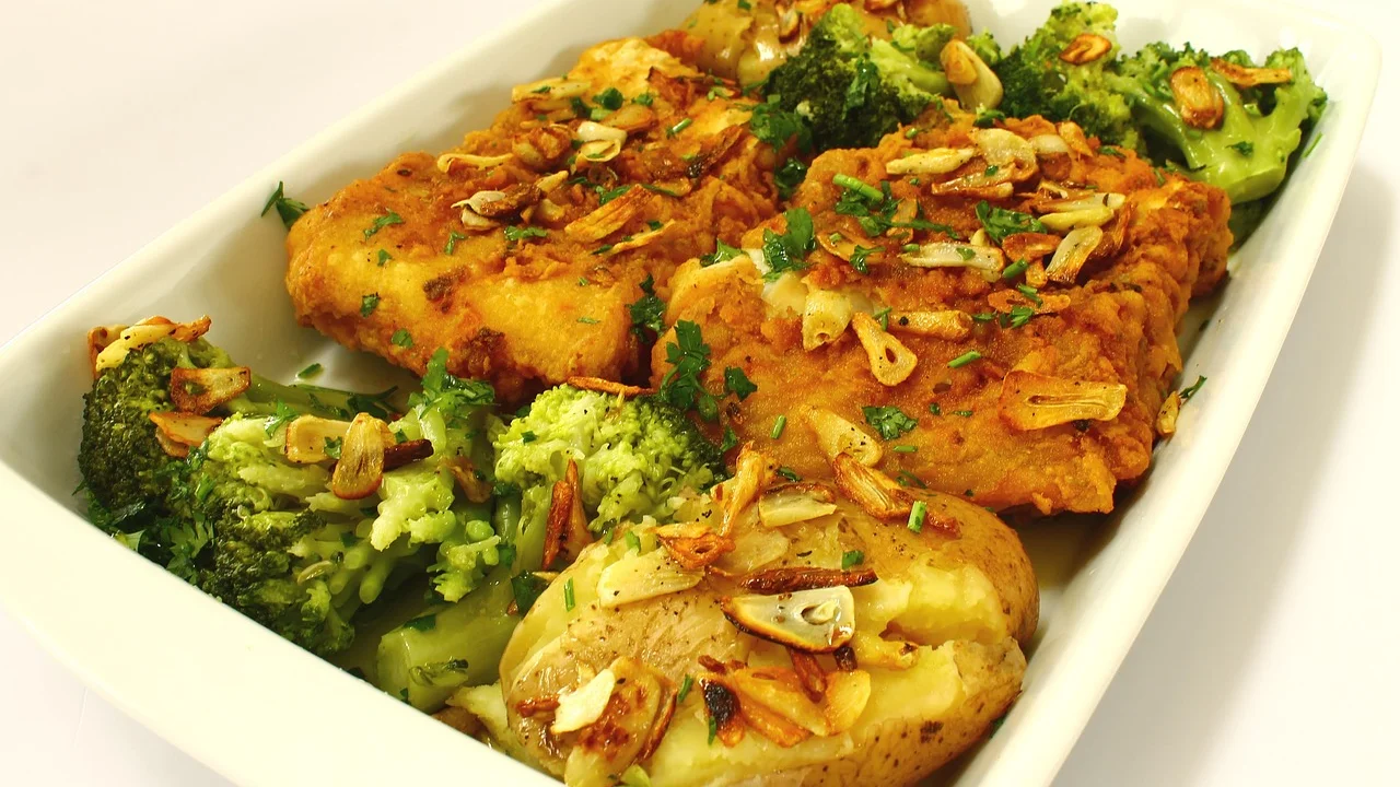 Travessa de bacalhau com batatas, ovos e azeitonas pretas.