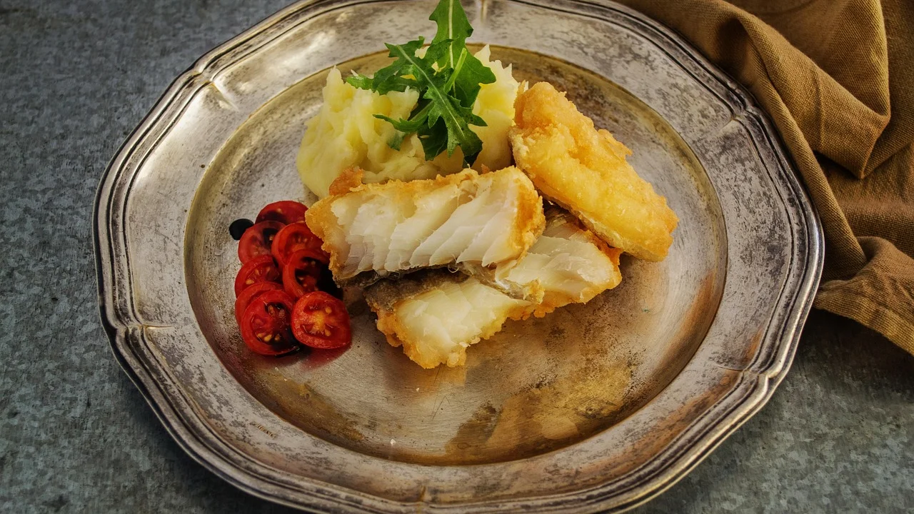Postas de bacalhau dessalgando em recipiente com água fria.