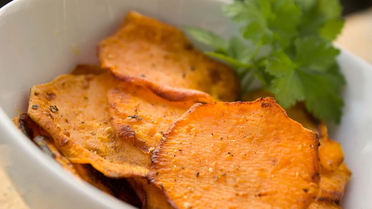 Palitos de batata-doce dourados no cesto da airfryer.