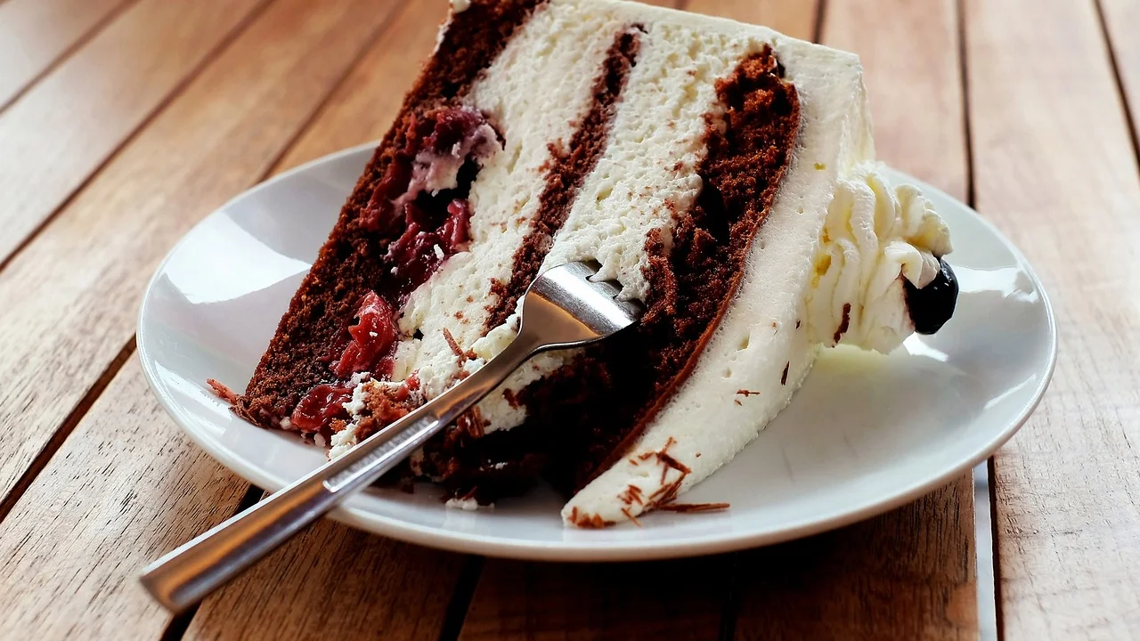 Café coado servido ao lado de fatias de bolo de fubá.