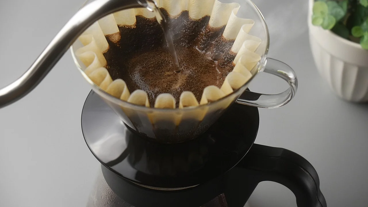 Grãos de café e moinho manual sobre a bancada