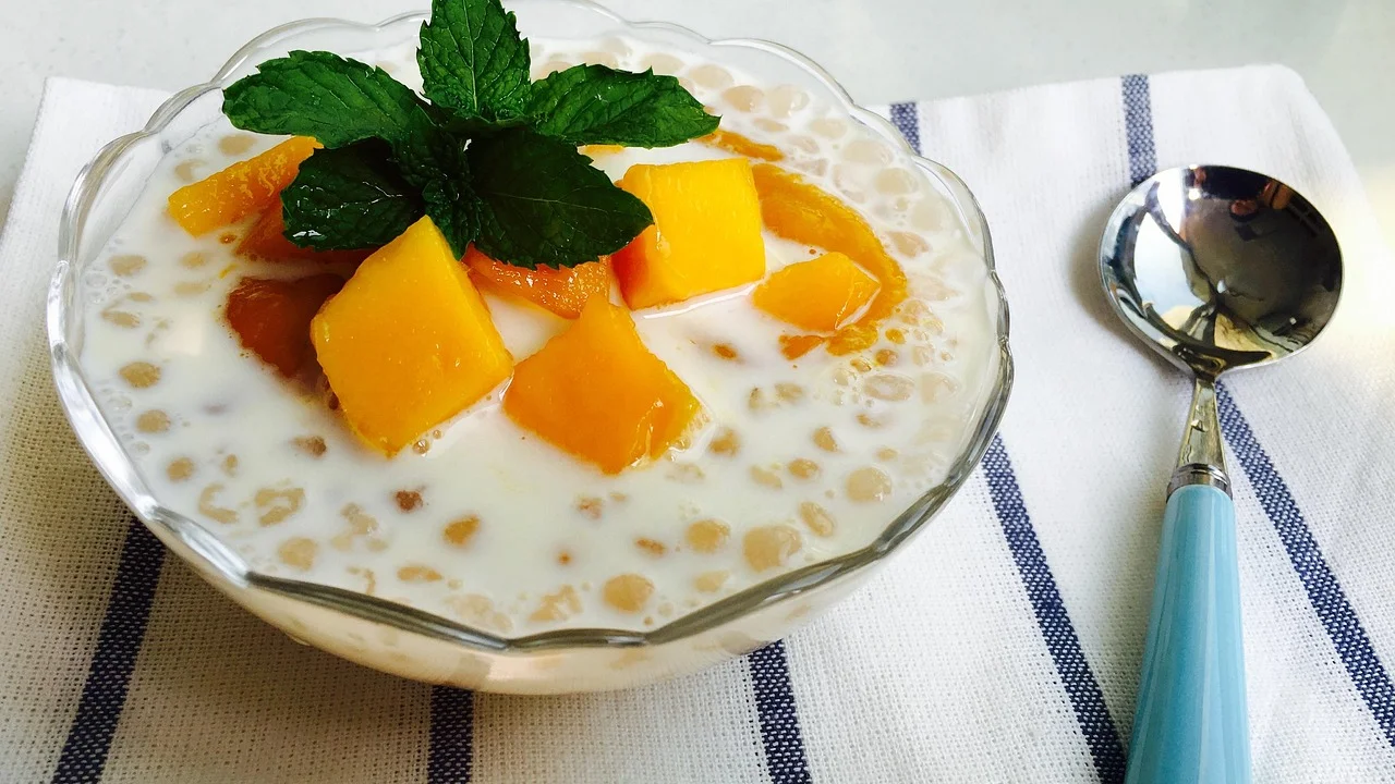Molho espesso de manga com pedaços visíveis de fruta.