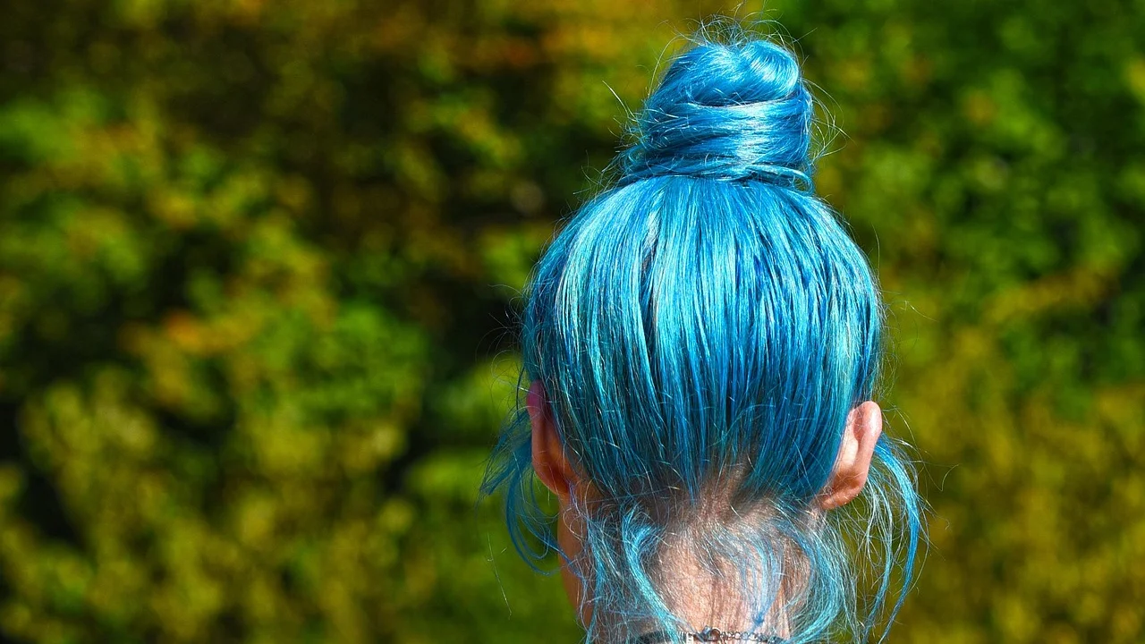 Coque alto despojado com mechas soltas ao redor do rosto.