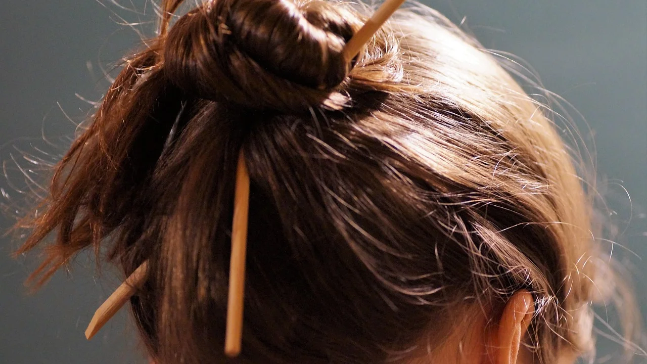 Coque alto com volume suave e mechas soltas ao redor do rosto.