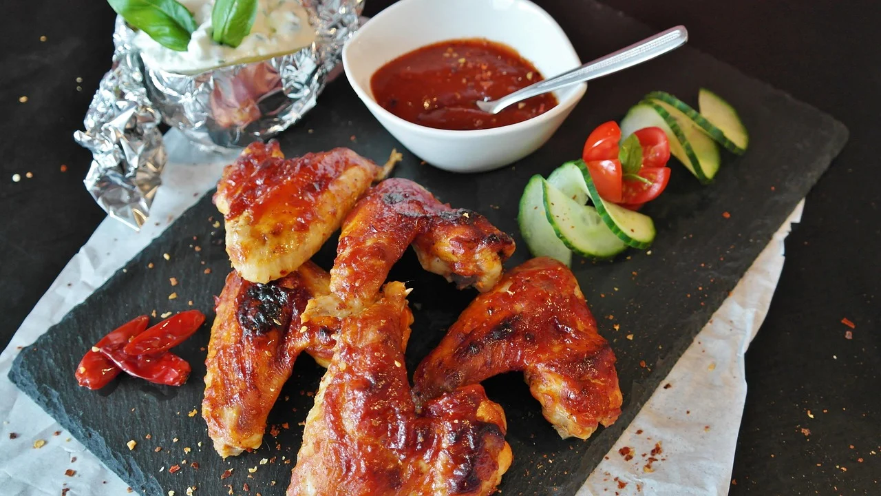 Petisco de frango servido com molho cremoso e limão.