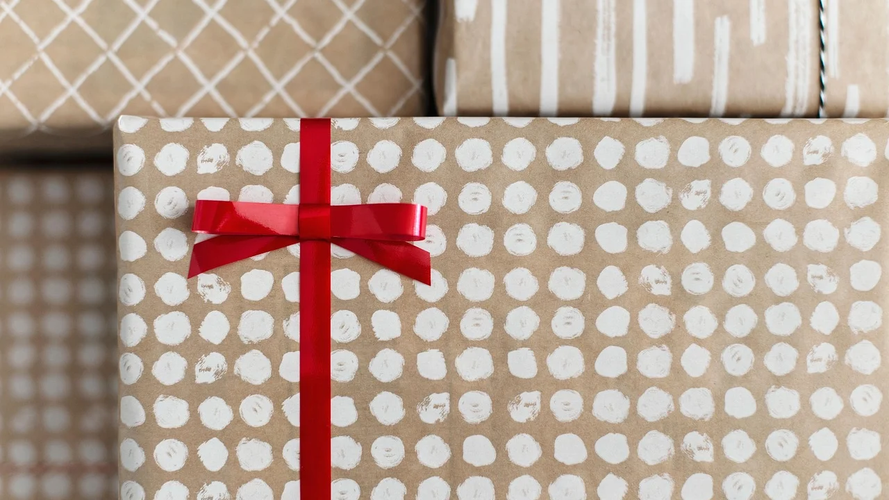 Laço de fita finaliza uma caixa embrulhada com papel estampado.