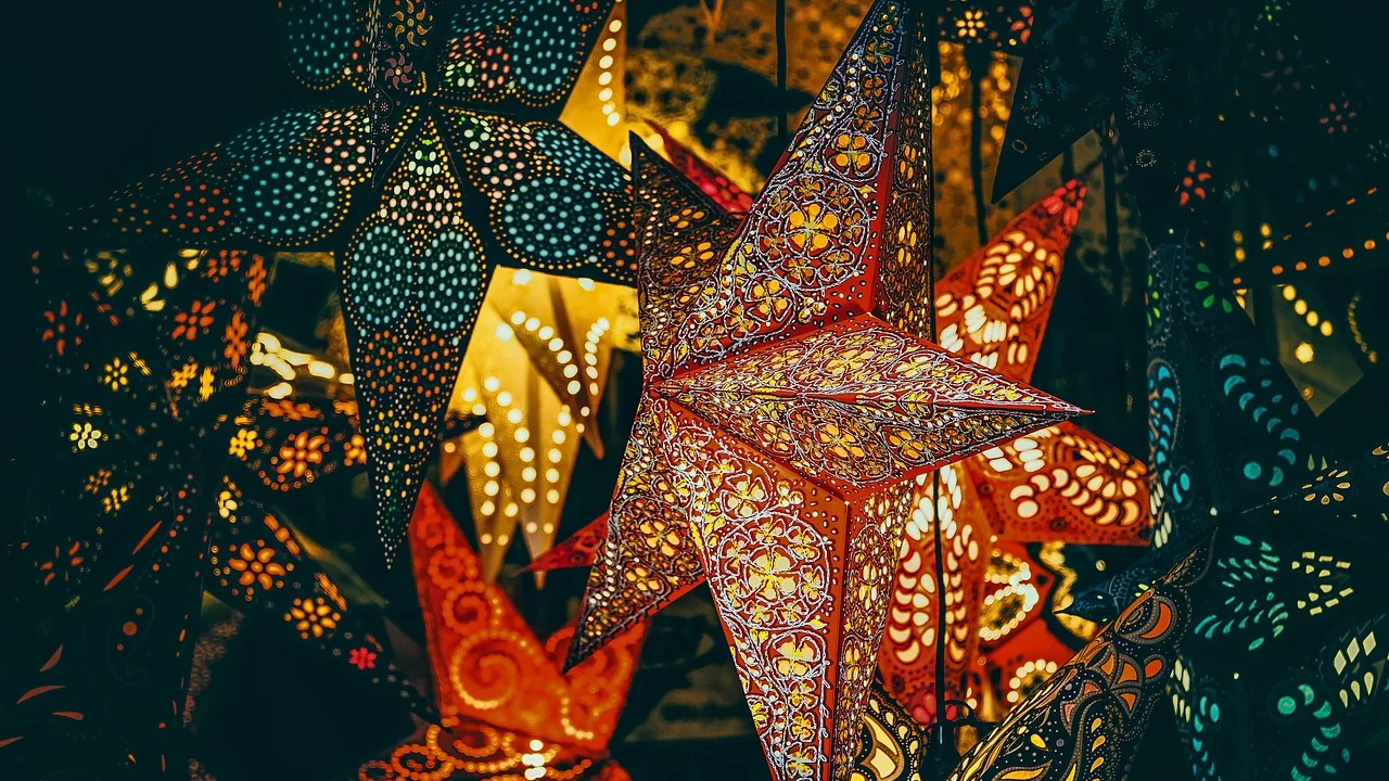 Estrelas de papel colorido em diferentes tamanhos sobre uma mesa.