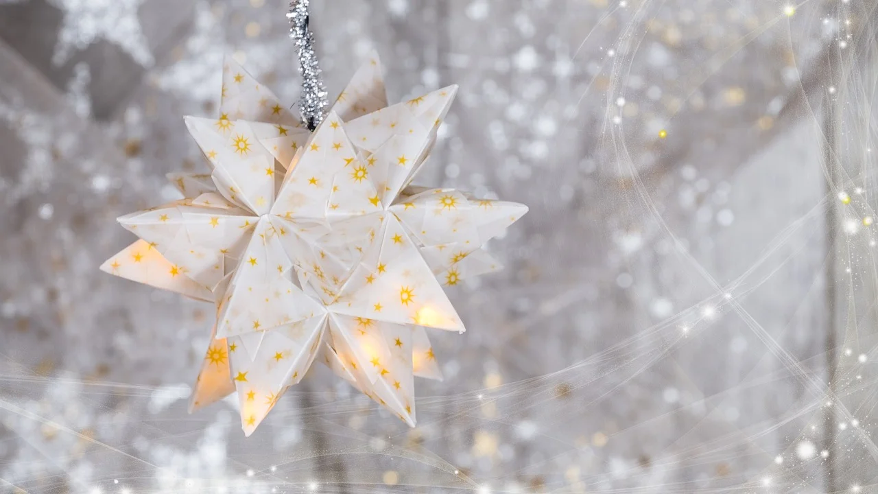 Duas partes de papel formam uma estrela decorativa em 3D.