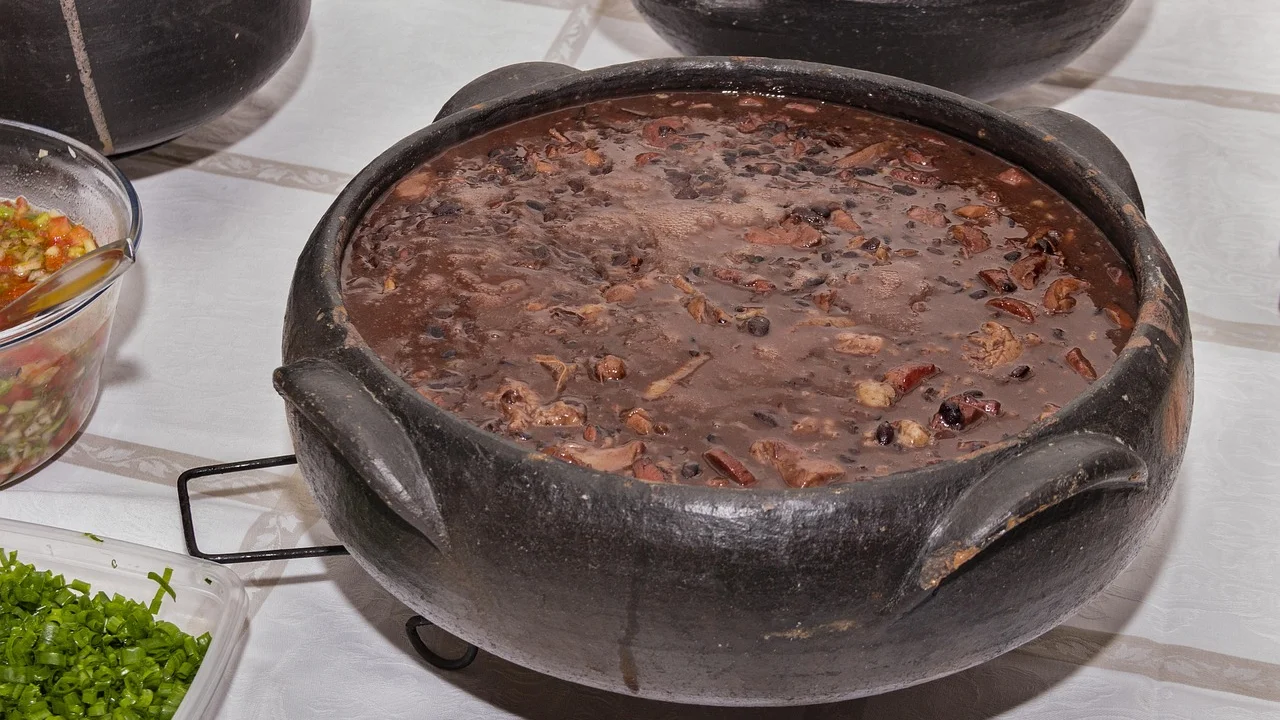 Feijão-preto e carnes cozinhando em panela grande