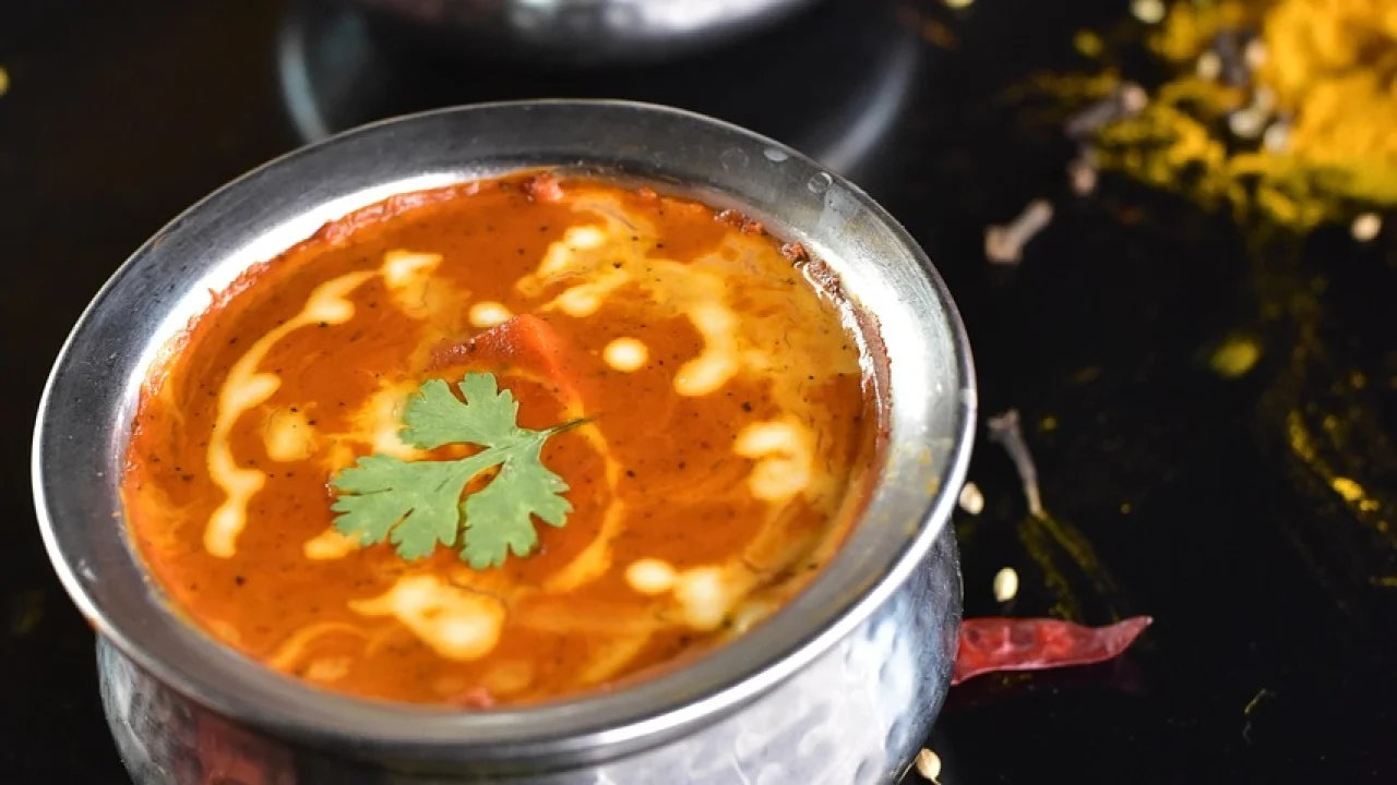 Prato de frango ao curry finalizado com coentro fresco.