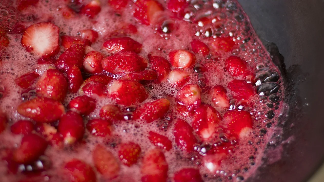 Pote de vidro com geleia de morango pronta para servir.
