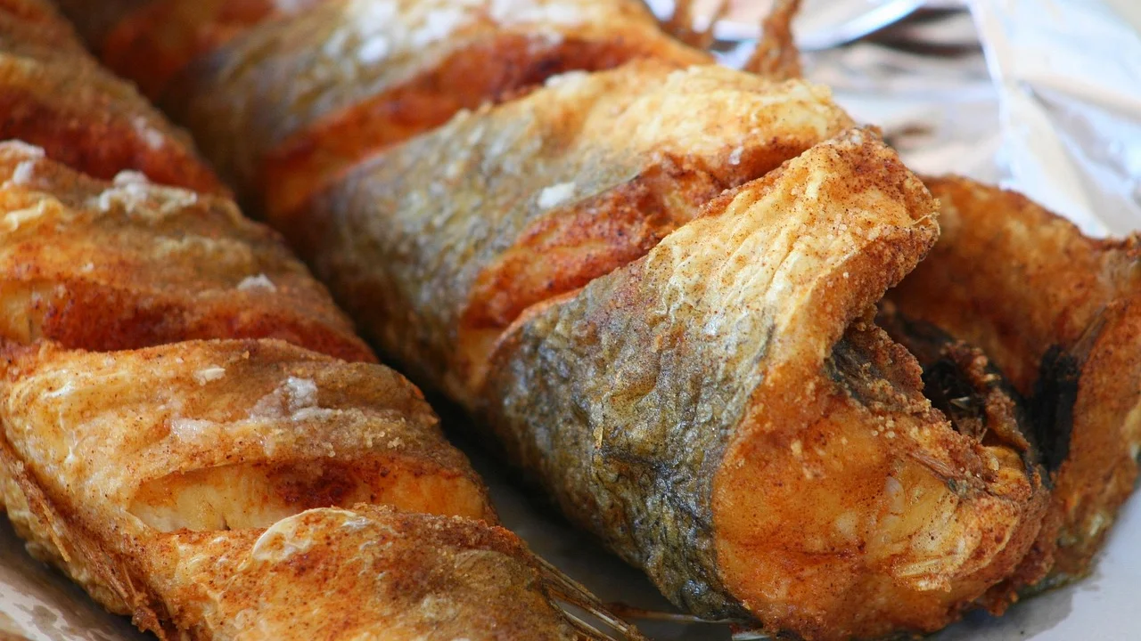 Iscas de peixe empanadas e douradas servidas com limão