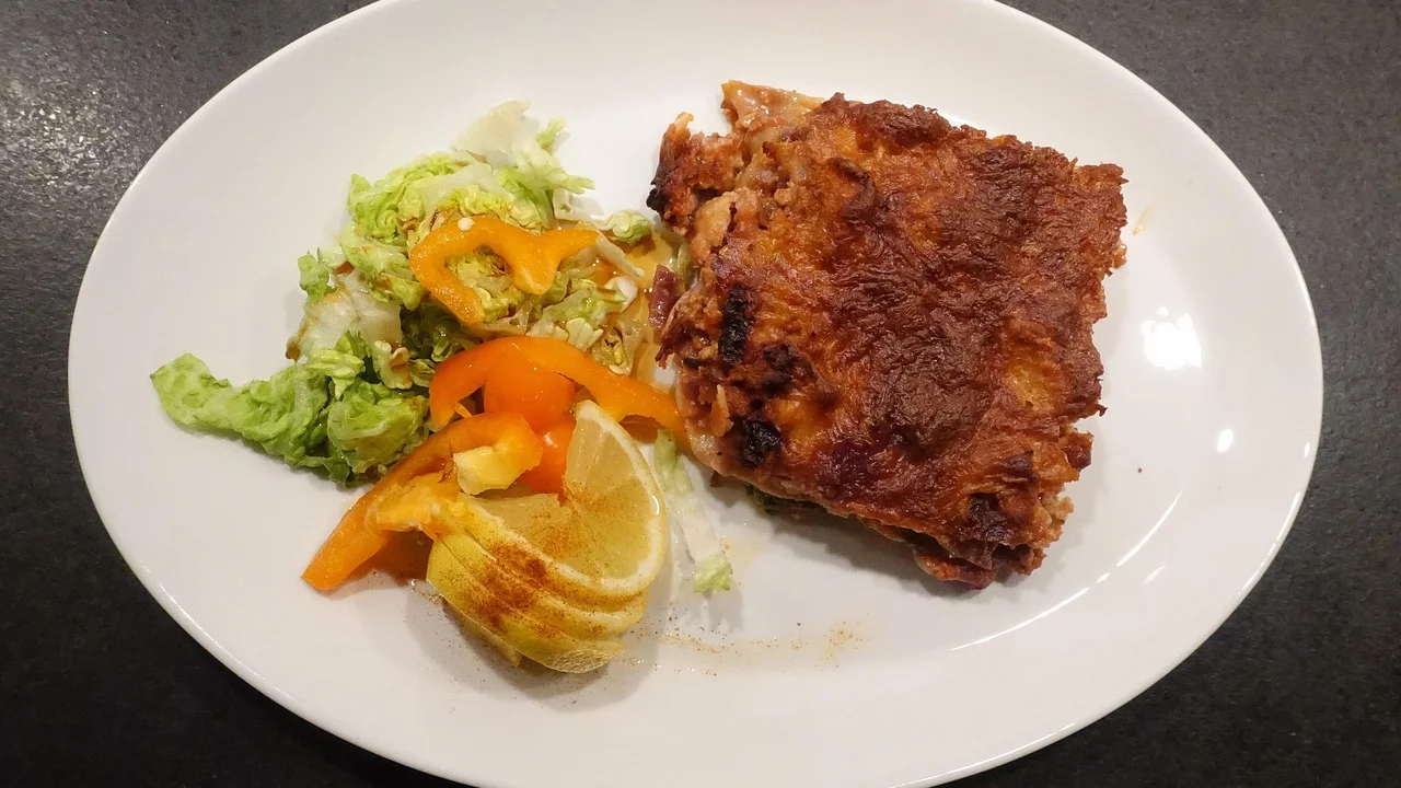Lasanha de frango gratinada em travessa de vidro recém-saída do forno.