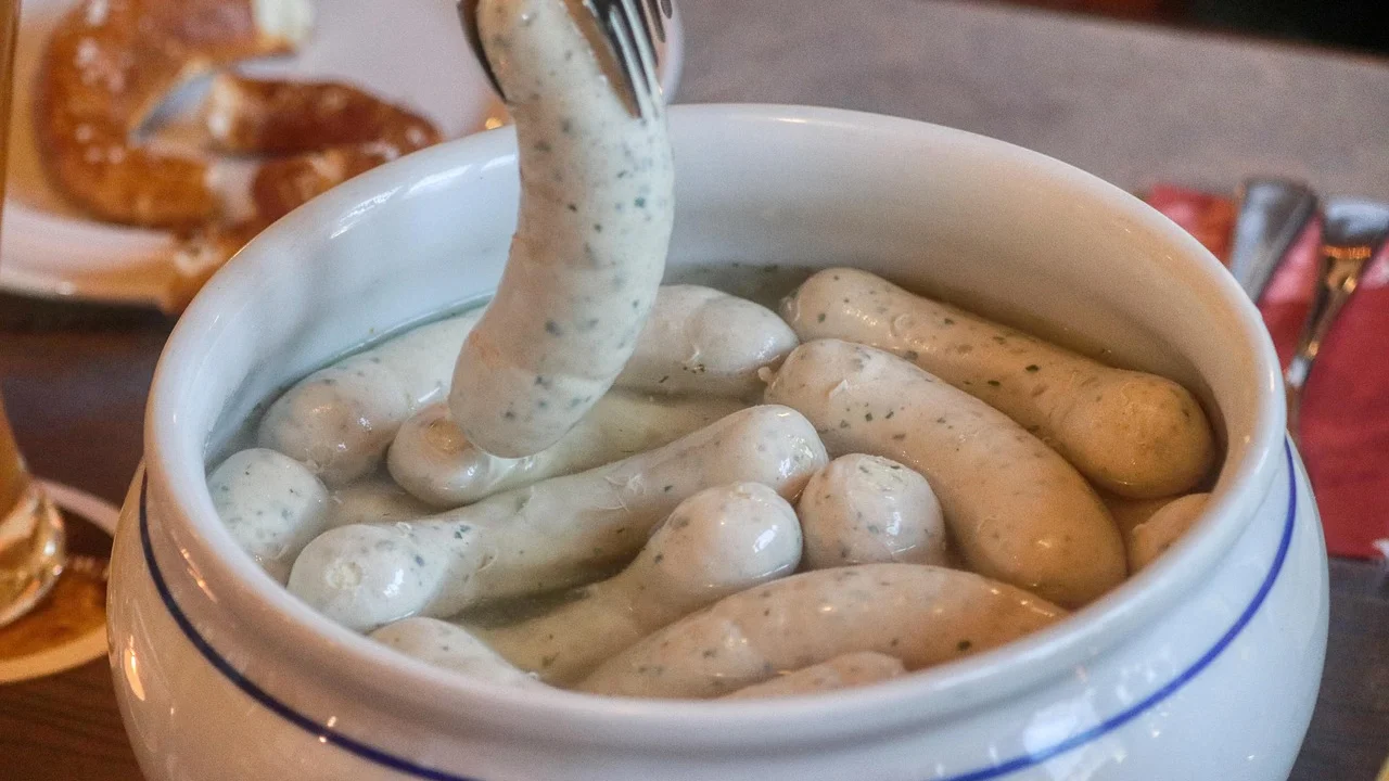 Linguiça assada servida com vinagrete, arroz e farofa.