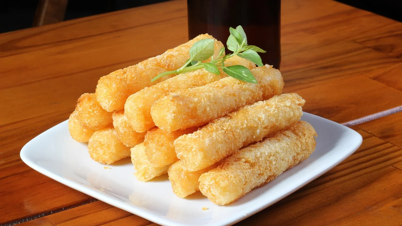 Mandioca dourada e macia preparada no cesto da airfryer.