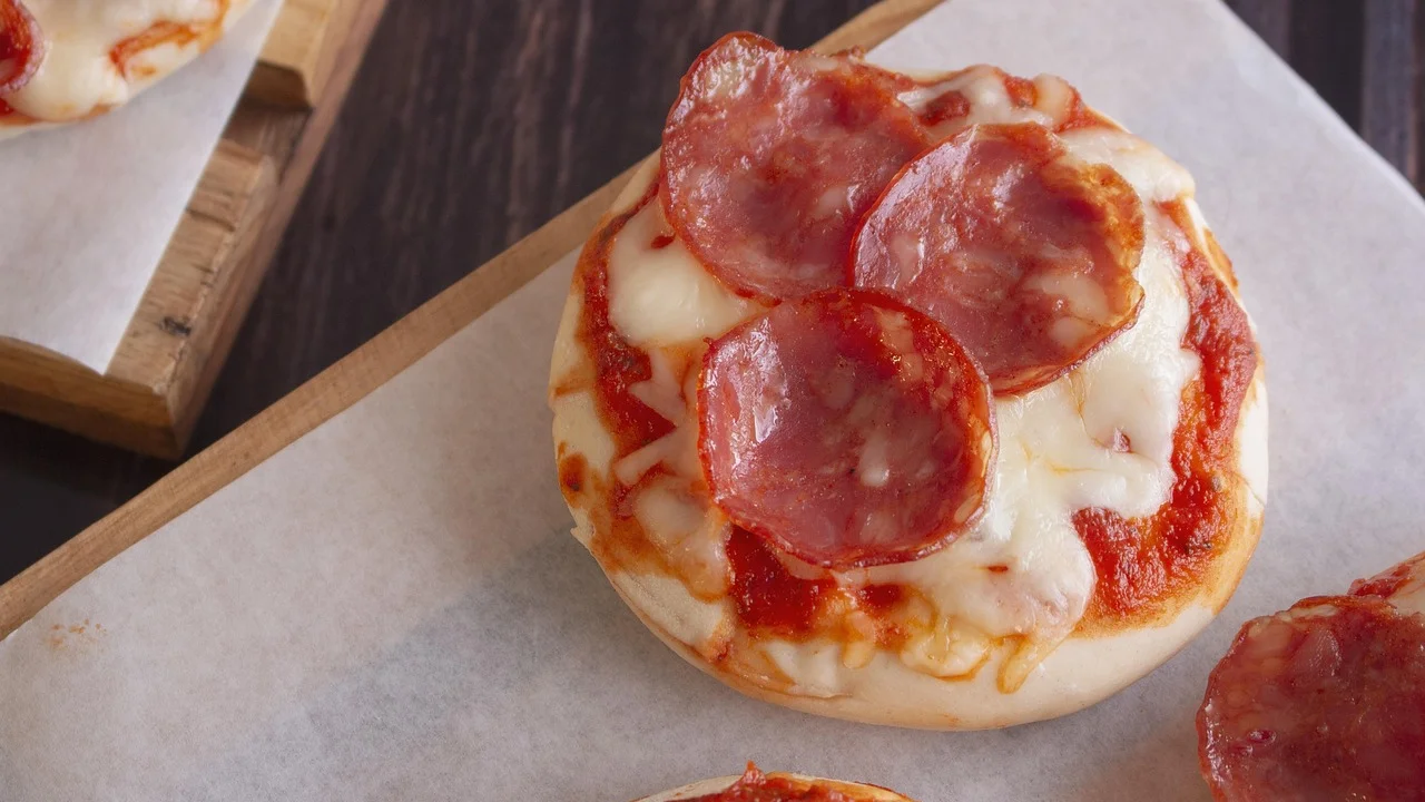 Mini pizzas caseiras com queijo derretido e molho de tomate