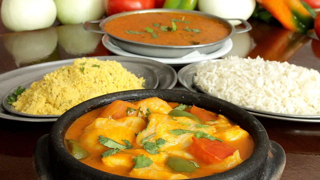 Moqueca capixaba servida em panela de barro com peixe e vegetais.