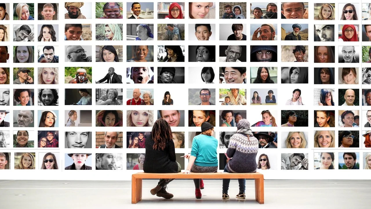 Grade metálica usada como mural de fotos em home office.