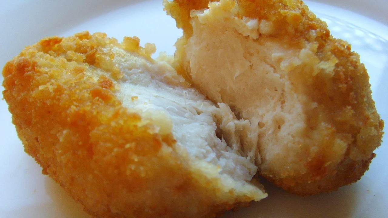 Nuggets dourados dispostos em uma única camada no cesto da airfryer.