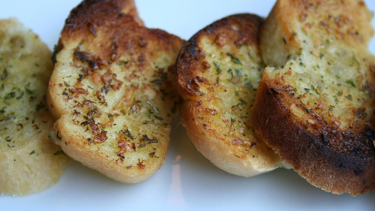 Pão de alho dourado na grelha com queijo derretido.