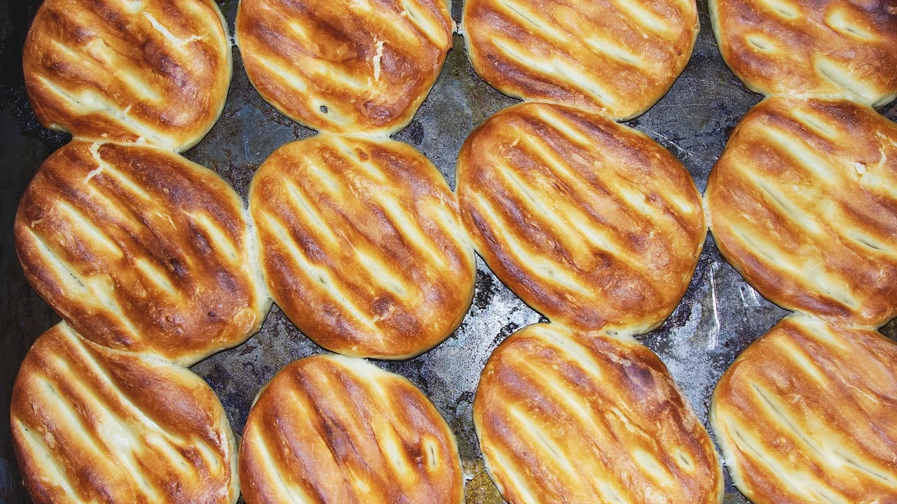 Pão sírio inflando em assadeira quente no forno.