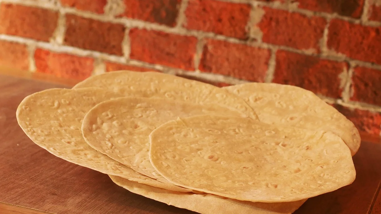 Triângulos de pão sírio tostados servidos com pasta de grão-de-bico.