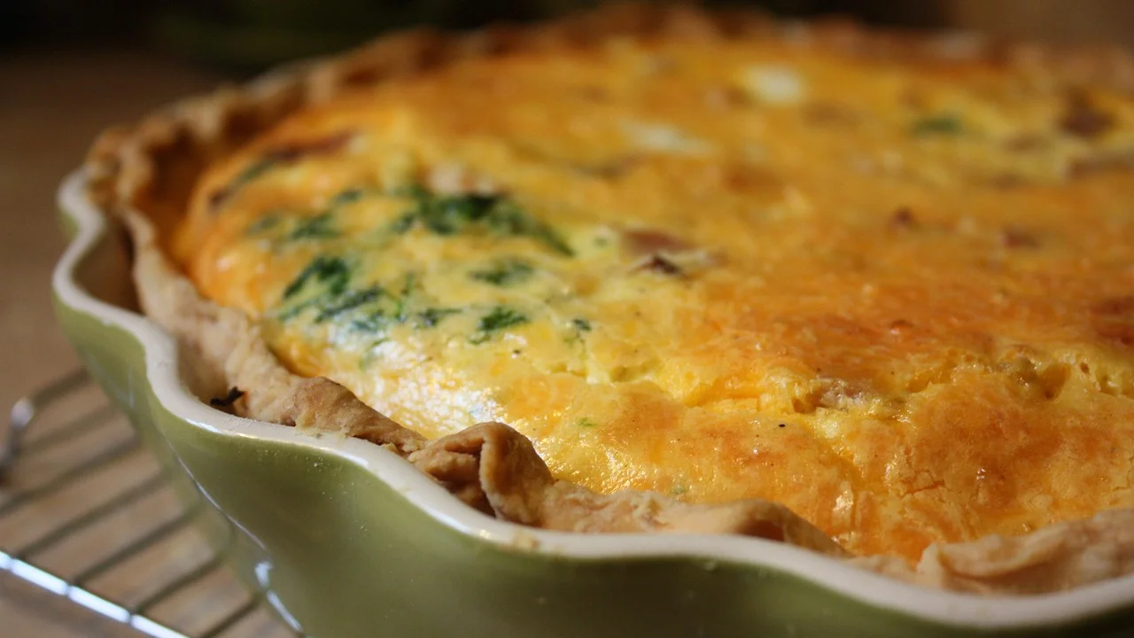Fatia de quiche de queijo servida com salada verde