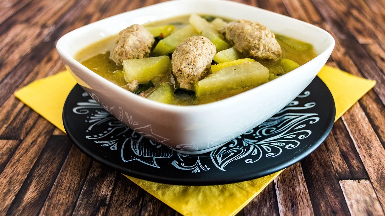 Prato de rabada servido com polenta cremosa e agrião.