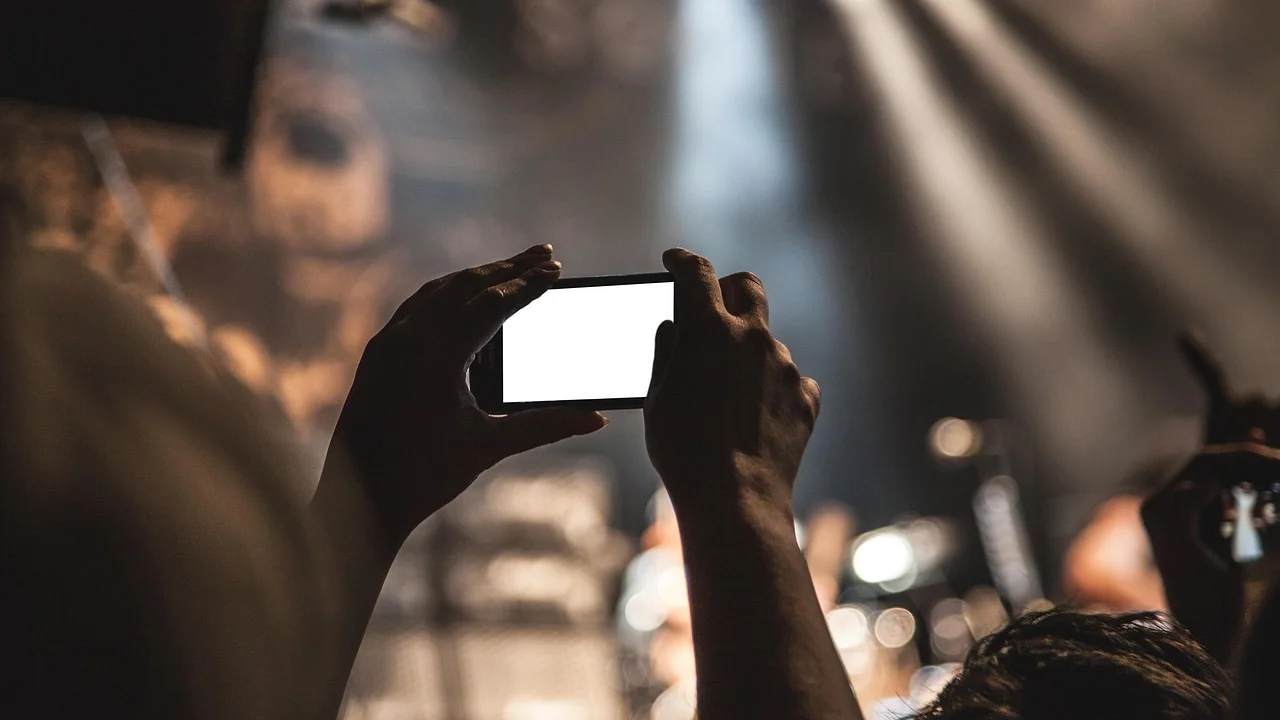 Pessoa gravando um vídeo vertical com o celular apoiado em tripé.