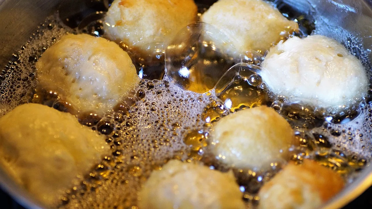 Rosquinhas fritas douradas finalizadas com açúcar e canela.