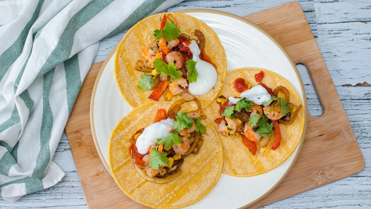 Mesa de tacos com acompanhamentos separados para montagem individual.