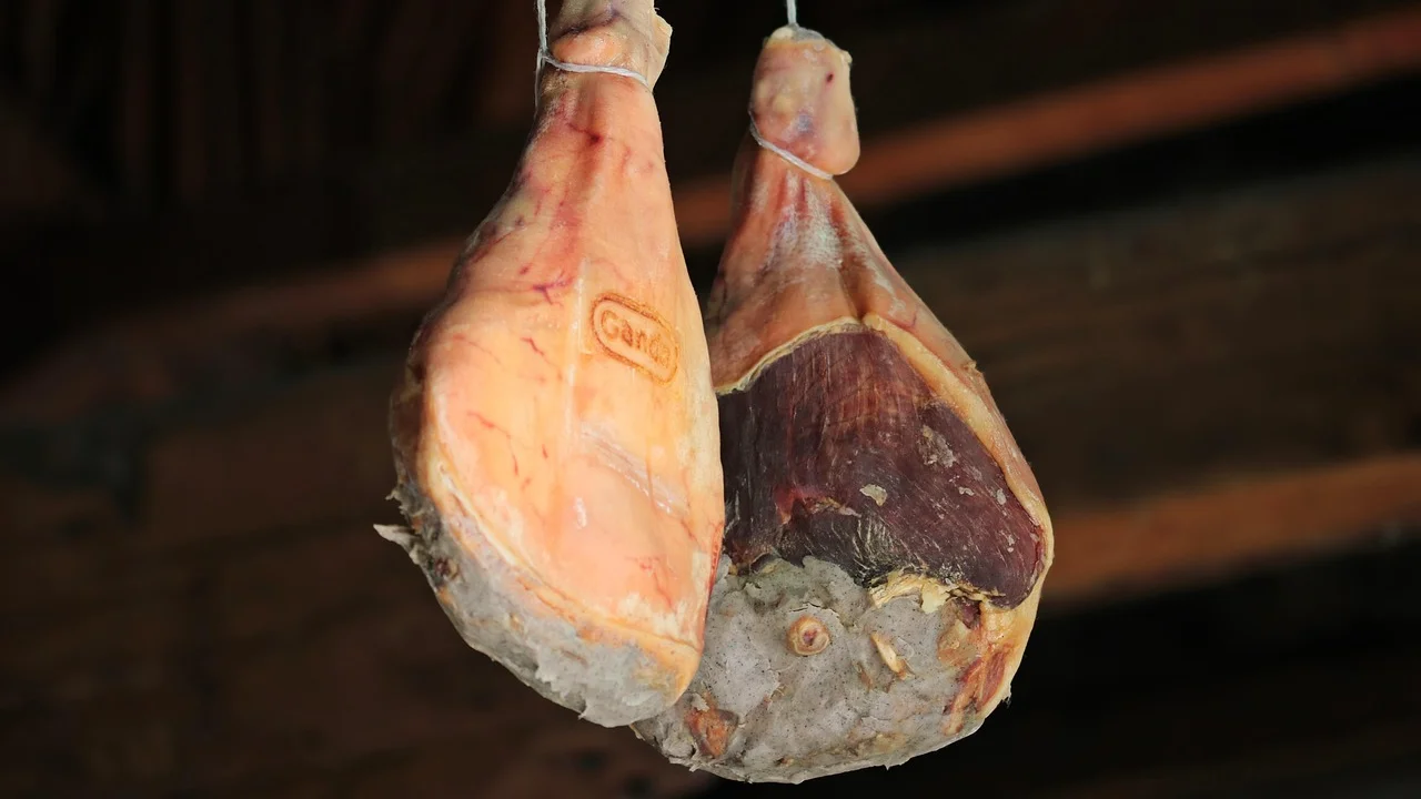 Fatias de tender servidas com molho agridoce em travessa.