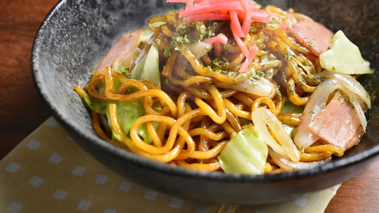 Yakisoba caseiro servido com macarrão, frango e legumes coloridos