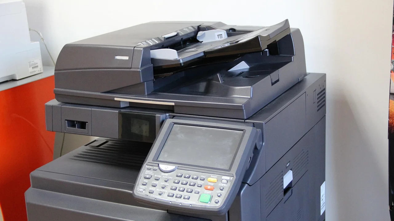 Mesa de trabalho com scanner e documentos organizados.