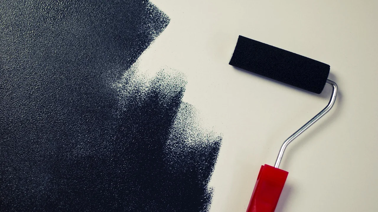 Rolo aplicando tinta branca em parede preparada