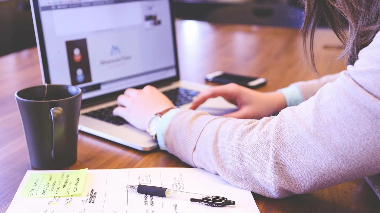 Celular conectado ao notebook por cabo USB para copiar fotos.