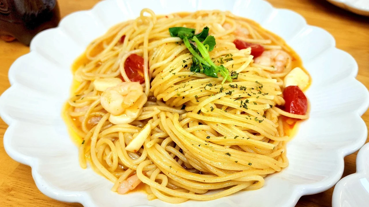 Espaguete cozido no ponto al dente sobre prato branco.